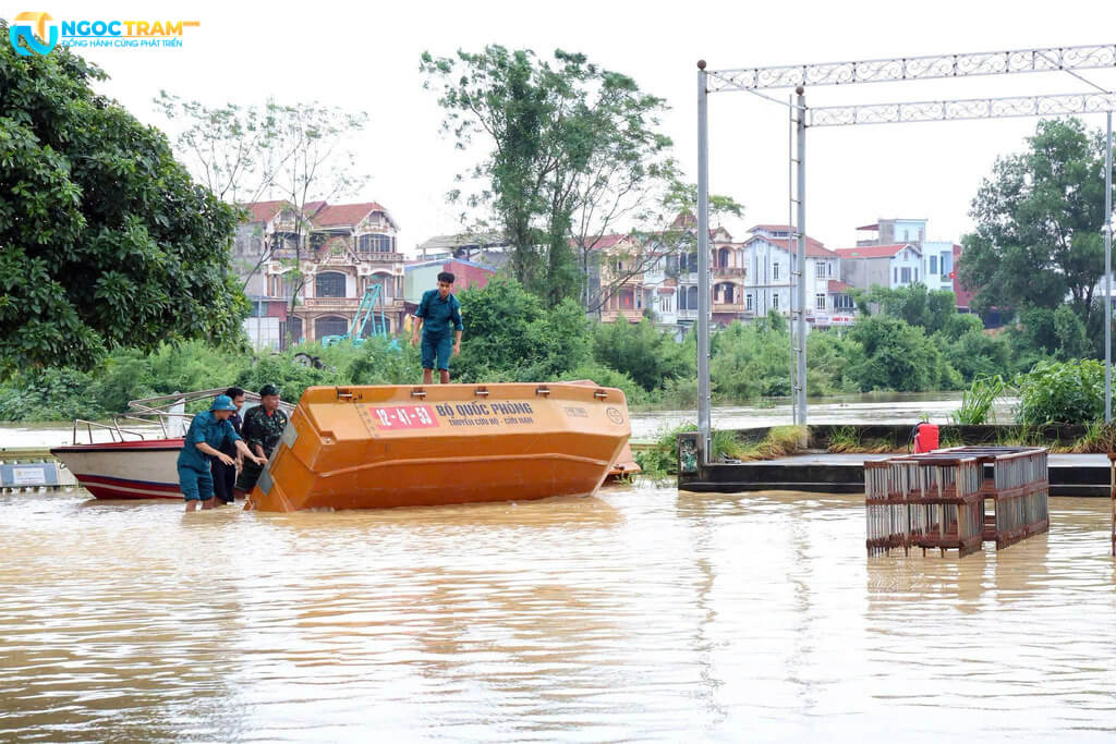 Lực lượng chức năng dùng thuyền hỗ trợ người dân trong khu vực ngập lũ.